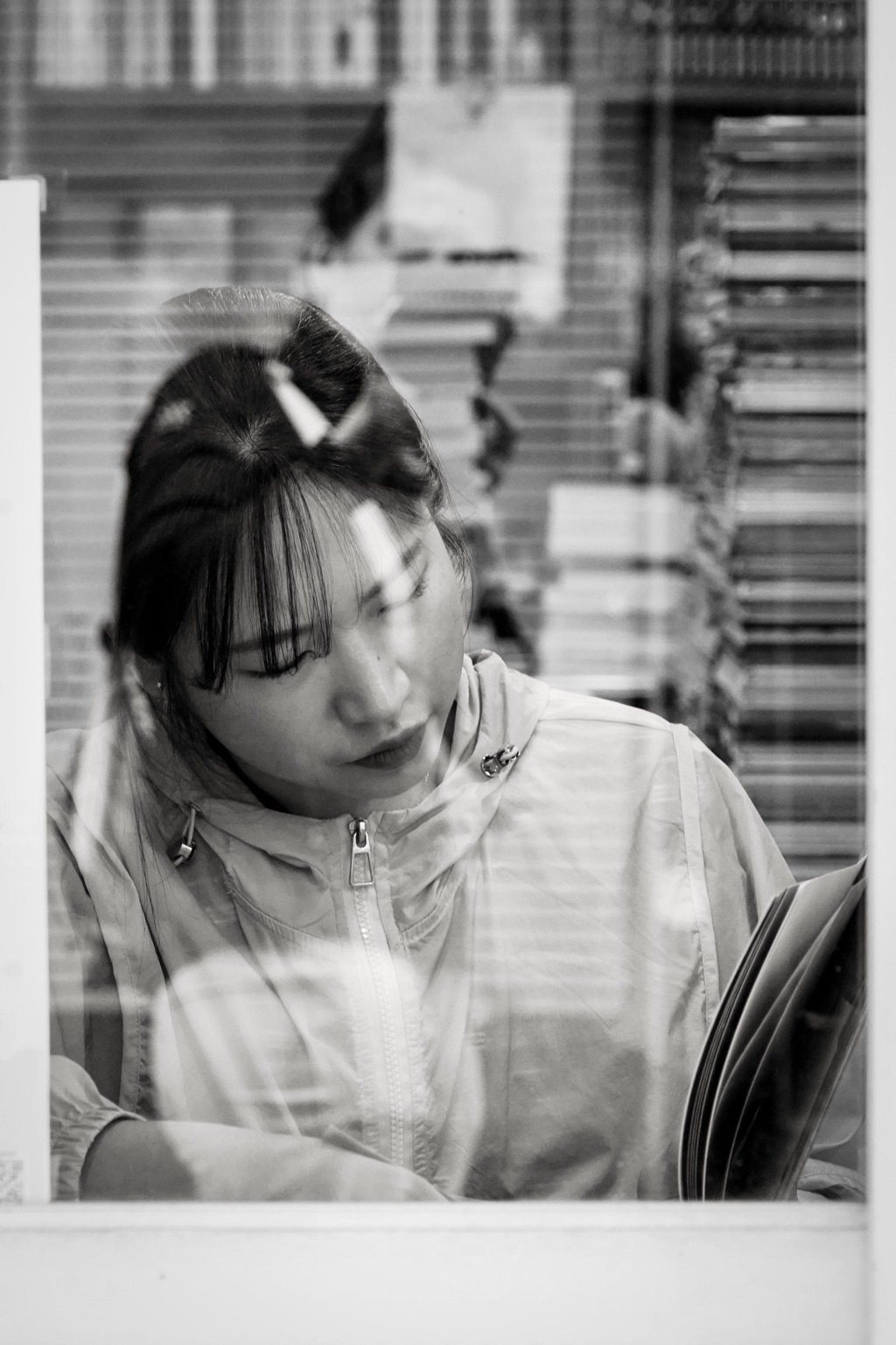 A woman reading behind glass in Busan