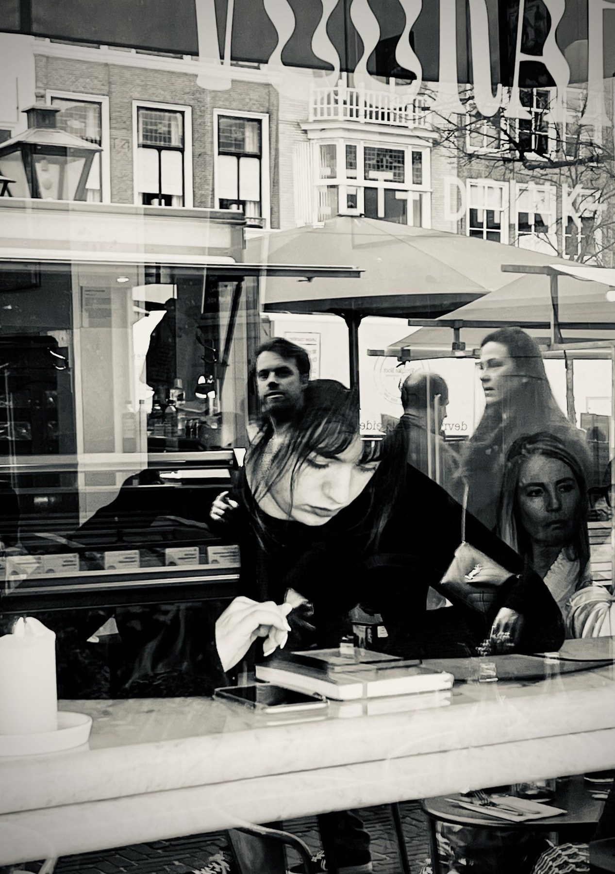 Layered café-window reflection in Leiden