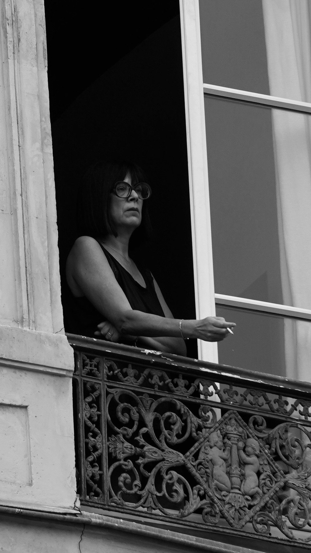 Woman standing at an open window in Paris