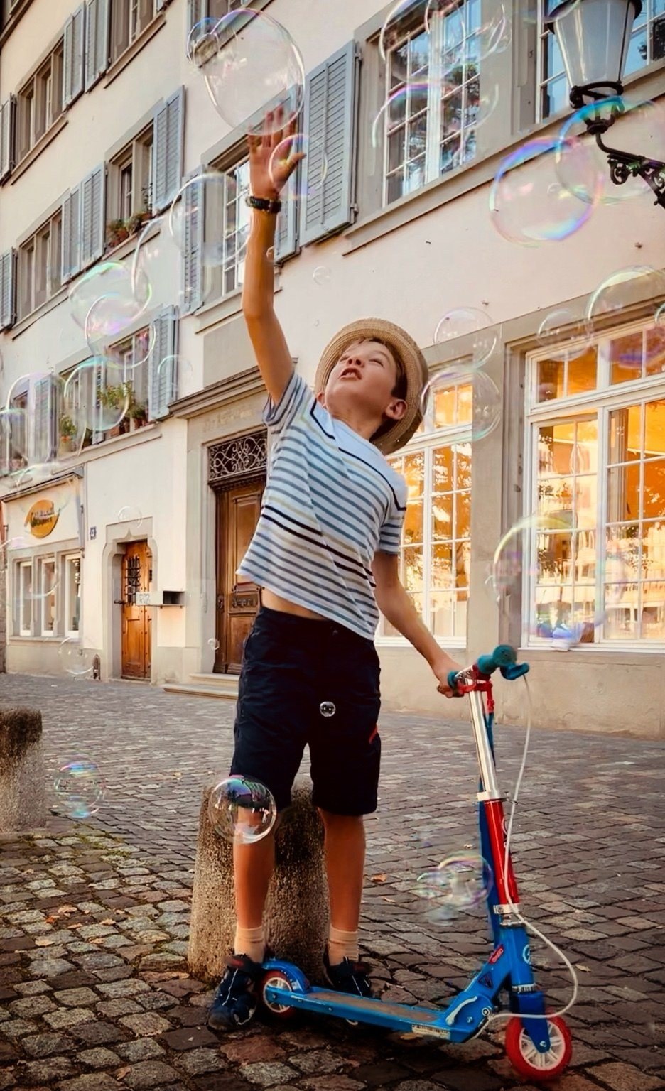 Child reaching for soap bubbles in Zurich
